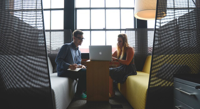 Developer and customer sitting side by side discussing a project